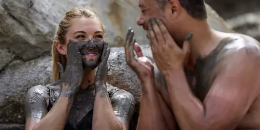 Couple laughing while applying geothermal mud at Hell’s Gate Rotorua.