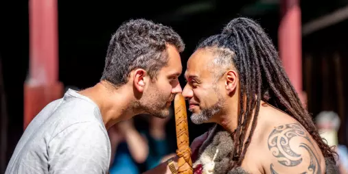 A guest and Māori host sharing a hongi greeting during a Te Pā Tū cultural welcome