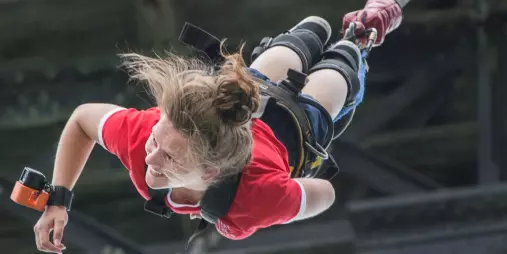 Woman smiling mid-fall during a solo bungy jump in Hanmer Springs