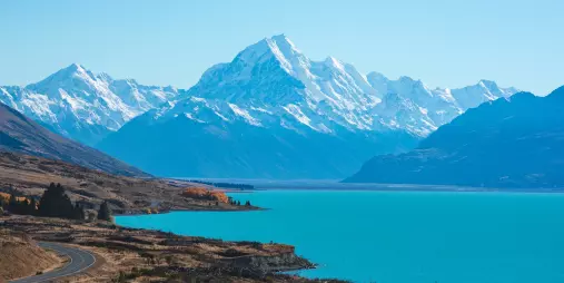 Aoraki/Mount Cook rising above Lake Pukaki with a clear blue sky and snow-covered peaks