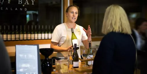 Cellar door host presenting wine at a Marlborough tasting room