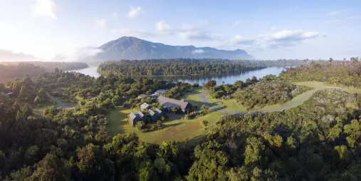 Aerial view of Waitai Lodge surrounded by bush near Martins Bay