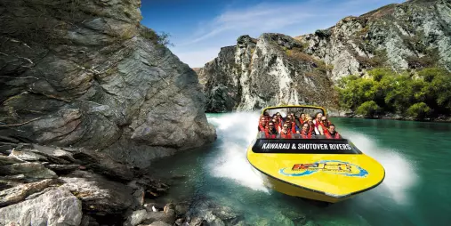 KJet jet boat powering through narrow canyon walls on the Shotover River