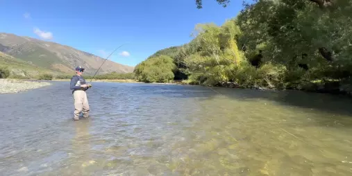 Angler softbait fishing in a clear Queenstown river on a 4x4-accessed backcountry adventure