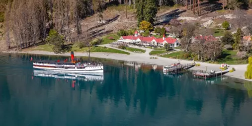 TSS Earnslaw docked at Walter Peak Station with homestead gardens in view