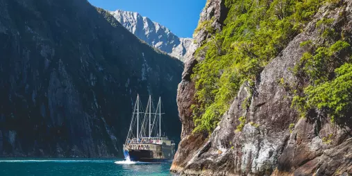 Milford Mariner cruising between towering cliffs in Fiordland National Park
