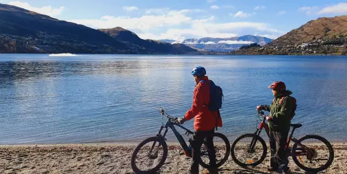 E-bike riders at Lake Whakatipu shoreline in Queenstown