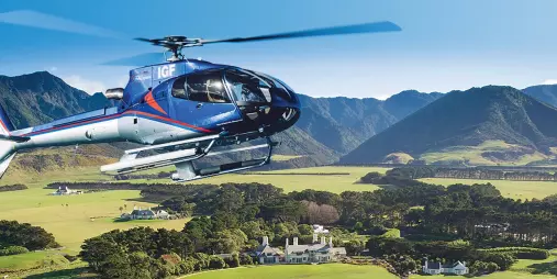 Helicopter flying over Wharekauhau Lodge with vineyard views near Wellington