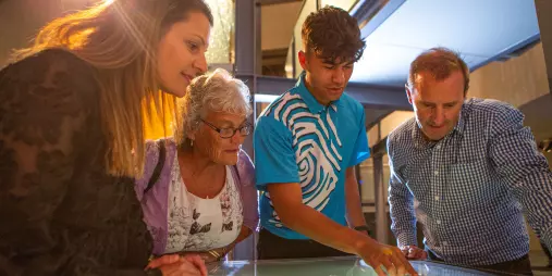 Visitors listening to a Te Papa guide during an interactive display about Māori history and culture.